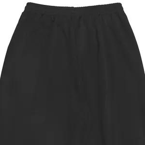 Detailed close-up showing the elastic waistband and texture of black loose trousers