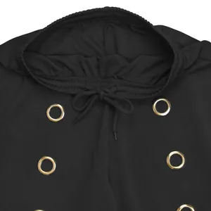 Close-up view of the elastic waistband on black wide-leg pants with decorative gold eyelets