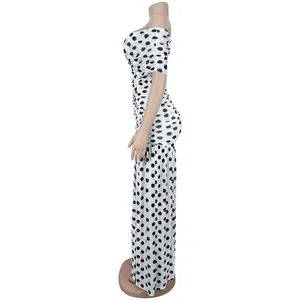 Seitenansicht eines weiß-schwarzen, schulterfreien, gerafften Maxi-Polka-Dot-Kleides