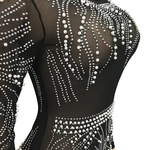 Detailed view of black sheer mesh dress with pearls and sparkling rhinestone patterns