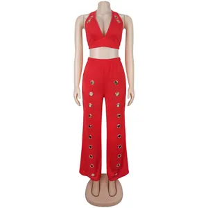 Stylish red two-piece set with halter top and wide-leg pants featuring gold grommets