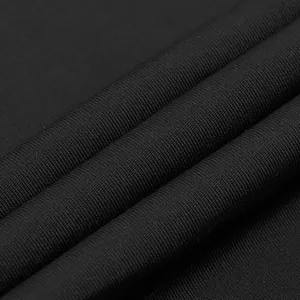 Macro close-up showing the fine knitted texture of the black stretch jumpsuit fabric