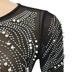 Close-up of black mesh dress with elegant pearl and rhinestone embellishments.