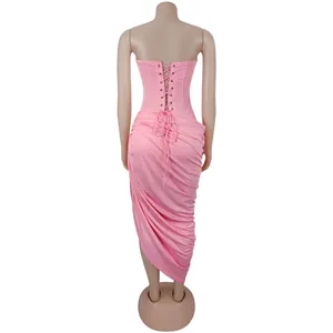 Back view of a pink lace-up corset and ruched bodycon skirt displayed on a beige mannequin