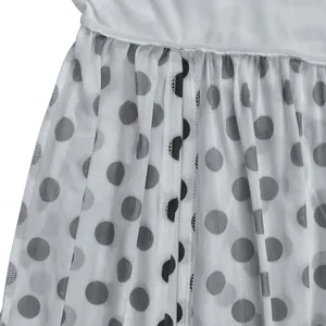 Nahaufnahme des weißen Netzgewebes mit klassischen schwarzen Punkten an einem Modekleid
