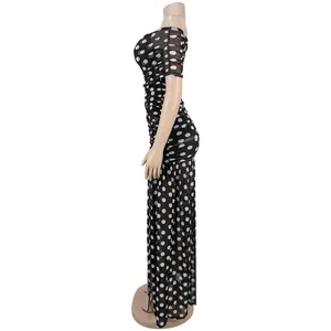 Seitenansicht eines schwarz-weißen gepunkteten Bodycon-Maxikleides mit Seitenschlitz