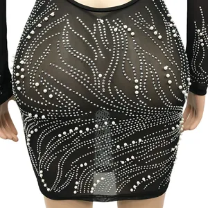 Close-up of black mesh mini dress featuring intricate silver rhinestones and white pearls