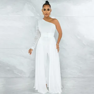 Full body view of white one-shoulder jumpsuit with mesh sleeve and flowy overskirt