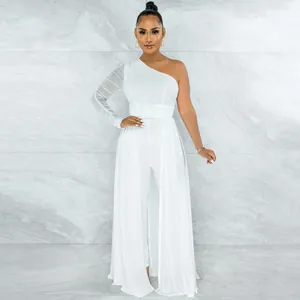 Detail of the sheer mesh sleeve and belt on an elegant white one-shoulder jumpsuit