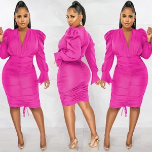 Detail view of a hot pink V-neck dress with long puff sleeves and ruched detailing.