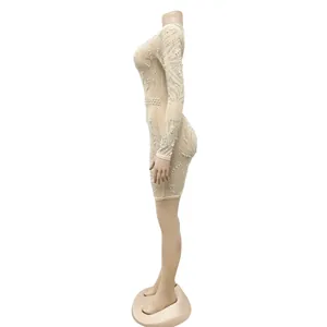 Side profile view of a sexy sheer mesh mini dress with rhinestones and pearls on a mannequin.