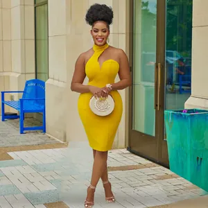 Stylish yellow halter neck off-shoulder bodycon midi dress worn by model in urban setting