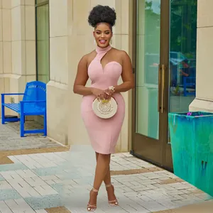 Elegant pink halter neck off-shoulder sleeveless midi dress worn outdoors by a model