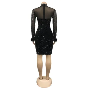 Back view of black sequined mini dress with sheer mesh and feather cuffs