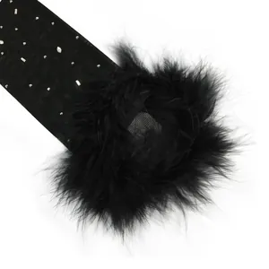 Close-up detail of black sheer mesh dress with rhinestones and lush feather trim