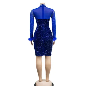 Detail of blue sequin dress featuring sheer mesh back and elegant feather cuffs.