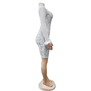 Side view of sparkling silver sequin mini dress with elegant white feather cuffs