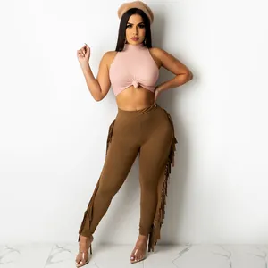 Fashion two-piece set featuring pink knotted crop top and brown fringed side leggings