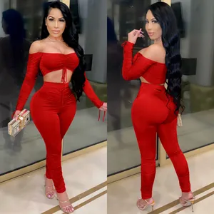 Détail d'un ensemble deux pièces rouge froncé avec haut à manches longues et legging moulant.