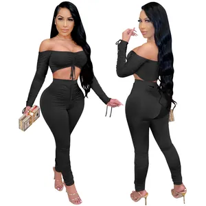 Vue de face et de dos d'un ensemble deux pièces noir avec haut dénudé et legging plissé.