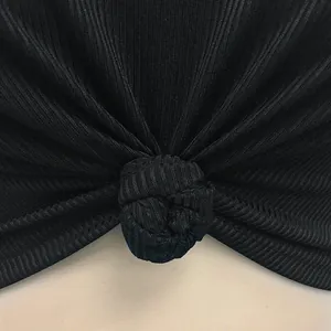 Detailed macro shot of high-quality black ribbed fabric featuring a stylish center knot.