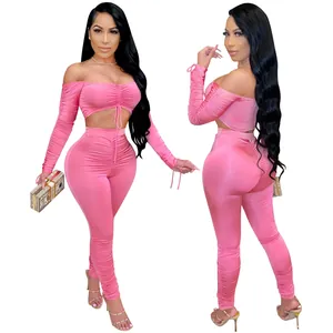 Ensemble deux pièces rose sexy avec haut froncé à épaules dénudées et leggings assortis.
