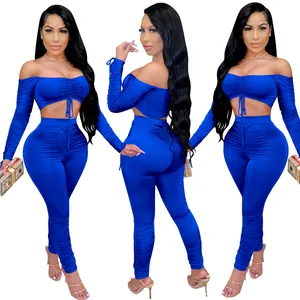 Détail d'un ensemble bleu deux pièces avec haut à épaules nues et pantalon froncé