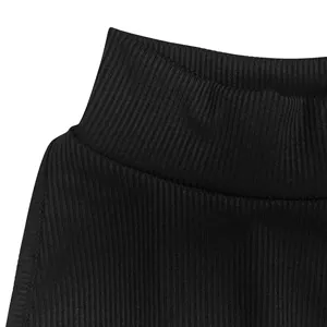 Close-up macro detail of black ribbed mock neck fabric on a stylish sleeveless top