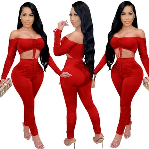 Ensemble deux pièces rouge avec haut court à épaules dénudées et leggings taille haute.