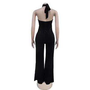 Achteraanzicht van een sexy zwarte fluwelen halter jumpsuit met open rug ontwerp