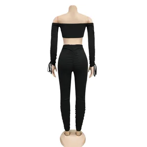 Vue arrière d'un ensemble deux pièces noir avec manches froncées et legging taille haute
