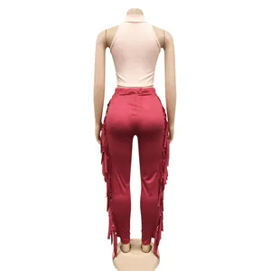 Back view of a chic pink sleeveless ribbed top and red fringed pants two-piece set.