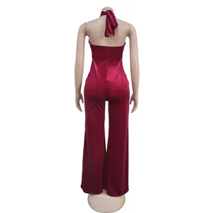 Achteraanzicht van een elegante rood fluwelen jumpsuit met open rug en wijde pijpen