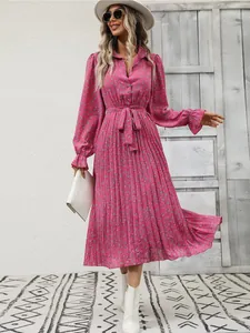 Close-up detail of a pink floral pleated maxi dress with elegant long sleeves and tie waist