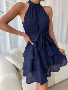 Close-up of navy blue halter sleeveless tiered ruffle dress with waist tie detail