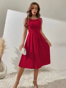 Detailaufnahme eines roten ärmellosen Prinzessinnenkleids mit elegantem Perlenbesatz.