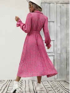 Stylish back view of a pink floral pleated long-sleeved midi dress with a waist tie.