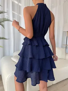 Back view of navy blue tiered ruffle halter dress showing textured fabric and layers
