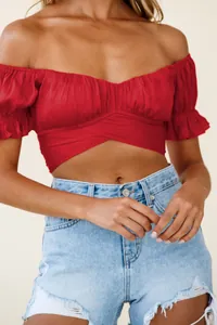 Detail showing a sexy red off-shoulder crop top with ruffle sleeves and wrap front