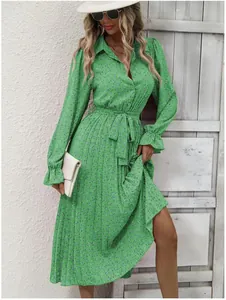 Detail view of a green floral pleated maxi dress with long sleeves and tie waist