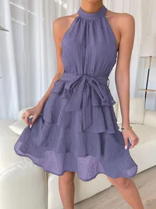 Detail view of the tiered ruffle hem and textured fabric of the purple halter dress