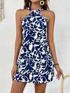 Detail view of the blue and white leaf print halter neck sleeveless mini dress on a model