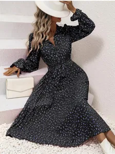 Close-up detail of a long-sleeved floral pleated dress featuring a stylish waist tie belt.
