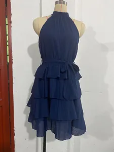 Dark blue sleeveless halter neck dress with layered ruffles on a mannequin stand