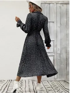 Elegant floral pleated maxi dress with long sleeves and tie waist detail.