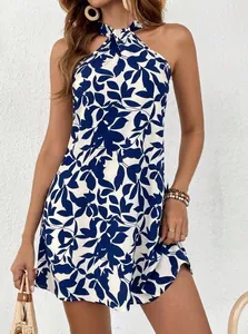 Detail view of the navy blue leaf print on a white halter-neck sleeveless mini dress.