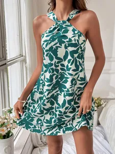 Detail view of a green and white leaf print halter neck mini dress for summer.