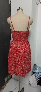 Back detail of a red floral print summer dress with smocked bodice on a mannequin.