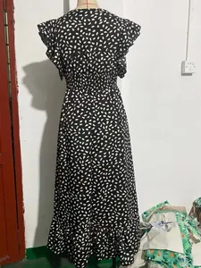Vista dettagliata del retro di un abito lungo a pois con scollo a V e maniche con volant.