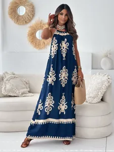 Boho-Maxikleid in Dunkelblau mit Blumenmuster und Halter-Ausschnitt an einem Model im Zimmer
